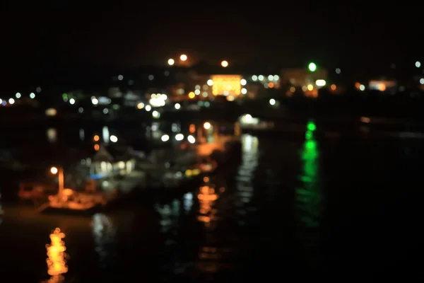 Luzes noturnas desfocadas borradas, bokeh do porto à noite . — Fotografia de Stock