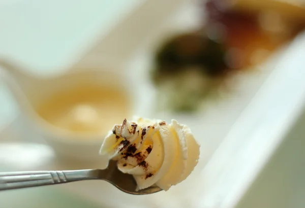 Spoon full with whipped cream with soiled plate on background. — Stock Photo, Image