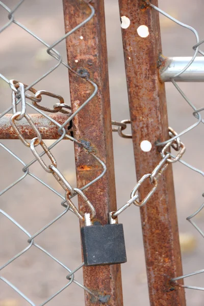 Metalik asma kilit ve zincir kilit çit kapıda. — Stok fotoğraf