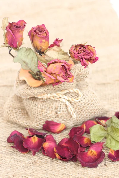 Букет сушеных роз и лепестков на мешковине — стоковое фото
