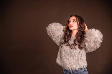 Siyah gri arka planda güzel bir kız. Model düşünüyor. Kazaklı ve kot pantolonlu kız. Boşluğu kopyala