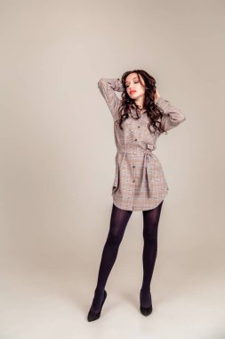 İzole edilmiş gri arka planda siyah uzun saçlı güzel bir genç kız. Uzayı kopyala Ayarlanmış