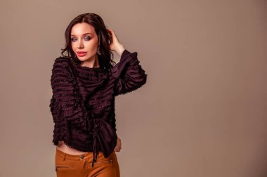Bir ton bej arka planda siyah uzun saçlı, ince, güzel bir genç kız. Kahverengi pantolonlu ve siyah bluzlu kadın. Boşluğu kopyala