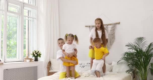 4 kinderen springen op het bed. rode meisjes en jongens — Stockvideo