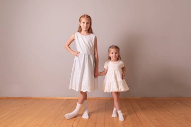 İki mutlu kız kardeş. Kırmızı ve sarışın kızlar. Kızlar el ele tutuşur