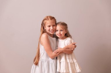 İki mutlu kız kardeş. Kırmızı ve sarışın kızlar. Kız kardeşler birbirlerini kucaklarlar.