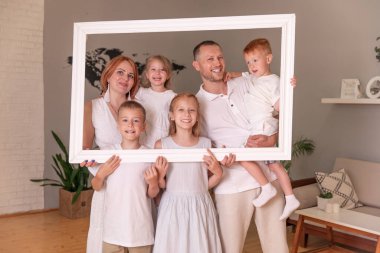 Büyük mutlu aile resim çerçevesi tutuyor ve gülümsüyor..