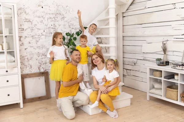 Merdivenlerde oturan aile gülümsüyor.