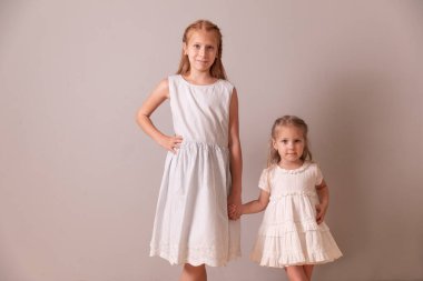 İki mutlu kız kardeş. Kırmızı ve sarışın kızlar. Kızlar el ele tutuşur