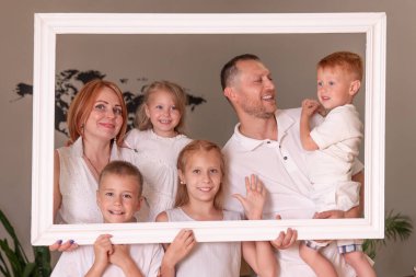 Büyük mutlu aile resim çerçevesi tutuyor ve gülümsüyor..