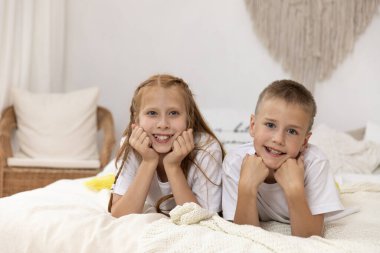 Çocuklar yatak odasında göbeklerinin üstünde yatıyorlar..