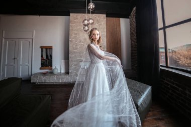 Bir sürü duvak. Süslü elbiseli gelin. Uzun kollu gelinlik. karanlık iç mekan