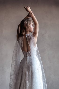 Gelinlik giymiş gelin ellerini kaldırıyor. arka plan