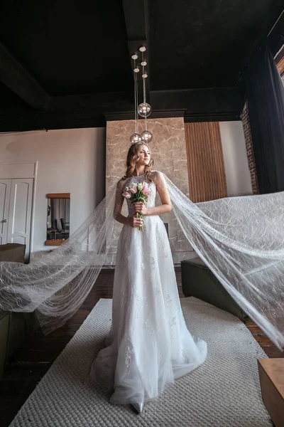 bride in fancy dress. wedding dress with long arms. dark interior