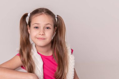 İzole edilmiş beyaz bir arka planda pembe elbiseli güzel bir kızın portresi. Boşluğu kopyala