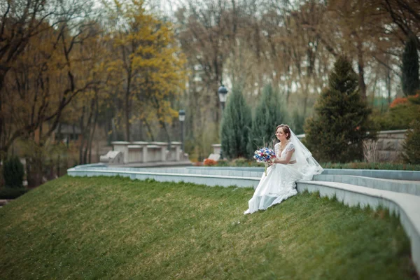 Nevěsta s kyticí v parku — Stock fotografie
