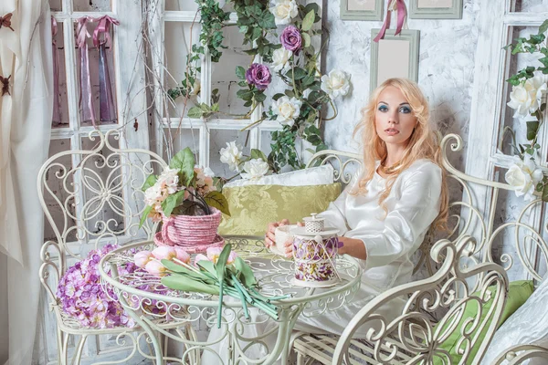 Menina loira no quarto com flores — Fotografia de Stock