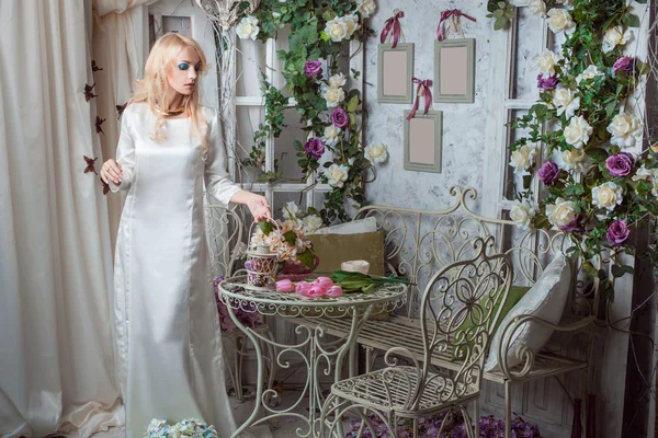 A menina em um belo vestido entre as flores — Fotografia de Stock