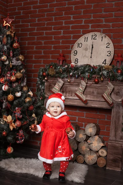 Dziecko przebrane za Świętego Mikołaja w pobliżu choinki — Zdjęcie stockowe