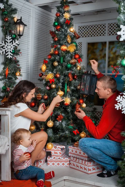 Familie siert een kerstboom — Stockfoto