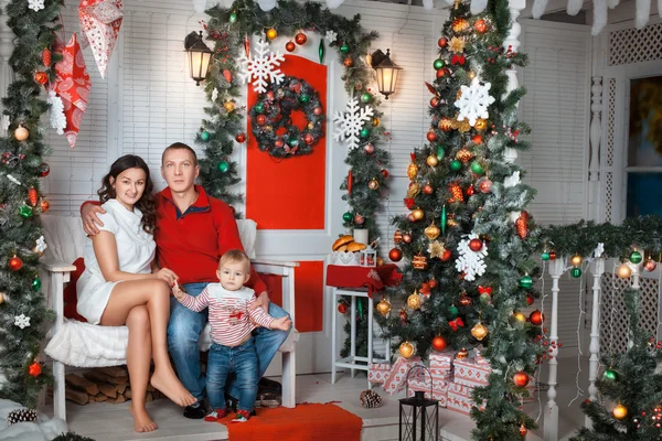 Jonge gezin in de buurt van de kerstboom — Stockfoto