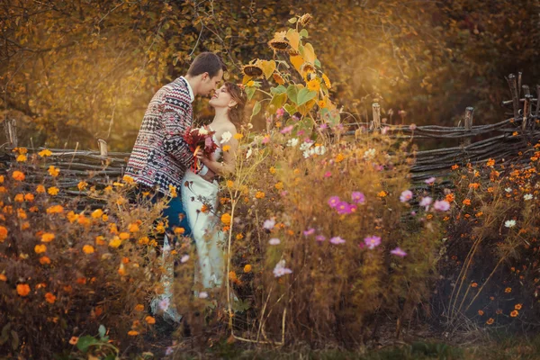 Recém-casados estão abraçando entre as flores — Fotografia de Stock