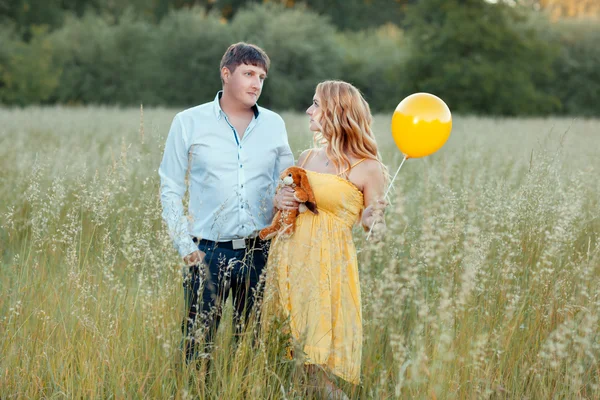 Муж и беременная жена в поле — стоковое фото