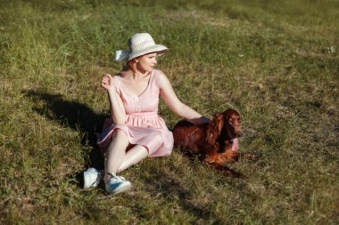 Köpek yanında bir kız çayırda