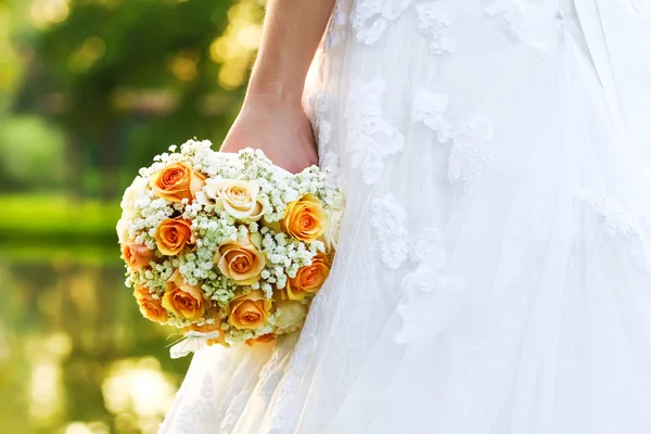 Wedding bridal bouquet of orange roses lying on wooden floor — Stock Photo, Image