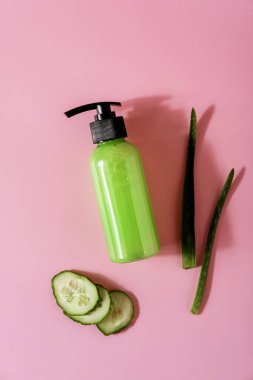 Aloe vera ve pembe arka planda salatalıklı kozmetik ürünleri. Mesaj için yer var. Düz konum