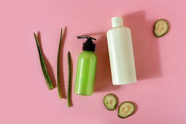 Aloe vera ve pembe arka planda salatalıklı kozmetik ürünleri. Mesaj için yer var. Düz konum