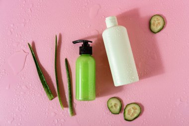 Aloe vera ve pembe arka planda salatalıklı kozmetik ürünleri. Mesaj için yer var. Düz konum