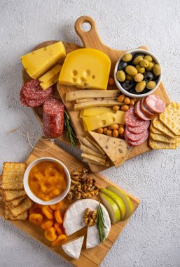 Farklı peynir türleri ve soğuk et çeşitleri. Beyaz arka planda üst görünüm. Çeşit çeşit peynirli fındık, kraker, zeytin, salam ve biberiye..