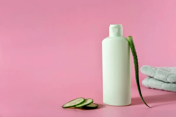 Cosmetic products with aloe vera and cucumber on pink backgroundr. Space for text.