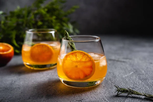 Biberiyeli Negroni. Siyah arka planda buz ve portakallı Negroni..