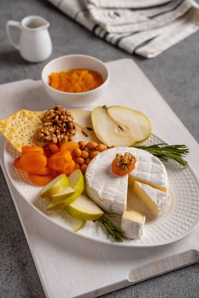 加坚果 梨子片和干杏仁的奶油奶酪 Camembert奶酪 在木板上的乳酪或Camembert乳酪 美味起司 图库图片
