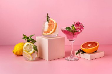 Meyveli sert maden suyu kokteylleri: armut, greyfurt, limon. Pembe arka planda renkli yaz içkileri.