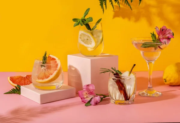 Meyveli sert maden suyu kokteylleri: armut, greyfurt, limon. Renkli yaz içkileri sarı arka planda gölge eğreltiotu ile ferahlatıcı.