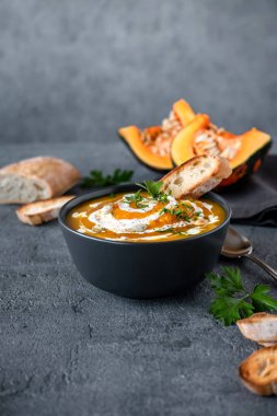 Koyu arkaplanlı balkabağı çorbası. Vejetaryen sonbahar balkabağı kremalı çorba ve kızarmış ekmek..