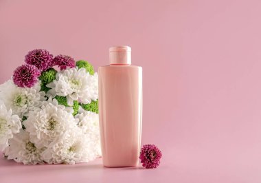 Doğal kozmetik ürünlerini taklit et: Serum, krem, açık pembe arka planda çiçeklerle reklam için maske. Organik ürünler. Spa konsepti