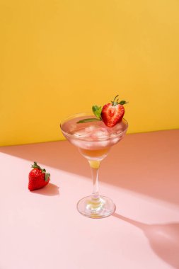 Sarı arka planda çilekli mojito kokteyli. Çilekli Mojito. Fotokopi alanı ile yaz içeceği tazeleniyor