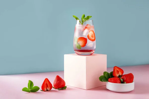 草莓Mojito蓝色背景和粉色讲台 以复印空间更新夏季饮品 免版税图库图片