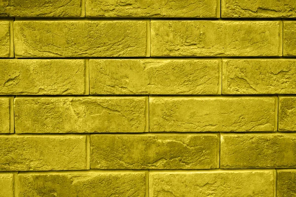 pattern of decorative yellow gray slate stone wall surface as a background. toned in illuminating and ultimate gray, trend color of the year 2021