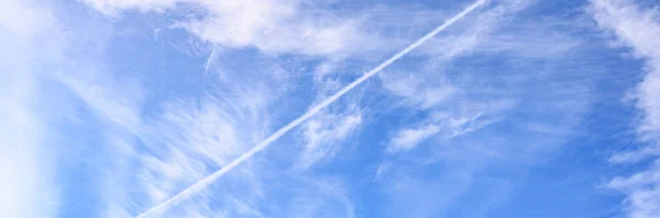 background of beautiful bright blue day sky with white cloud and trail from the plane. banner