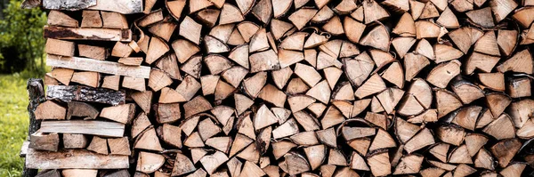 a woodpile with harvesting and stacked firewood of chopped wood for kindling and heating the house. firewood of the birch tree. banner