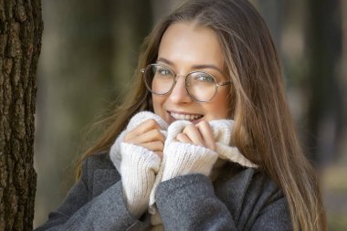 Güneşli bir sonbahar gününde genç ve güzel bir kız parkta yürüyor..