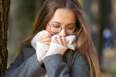 Güneşli bir sonbahar gününde genç ve güzel bir kız parkta yürüyor..