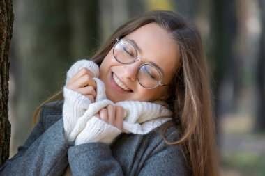 Güneşli bir sonbahar gününde genç ve güzel bir kız parkta yürüyor..