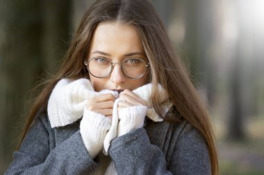 Güneşli bir sonbahar gününde genç ve güzel bir kız parkta yürüyor..