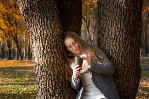 A young beautiful girl walks in the park on a sunny autumn day.